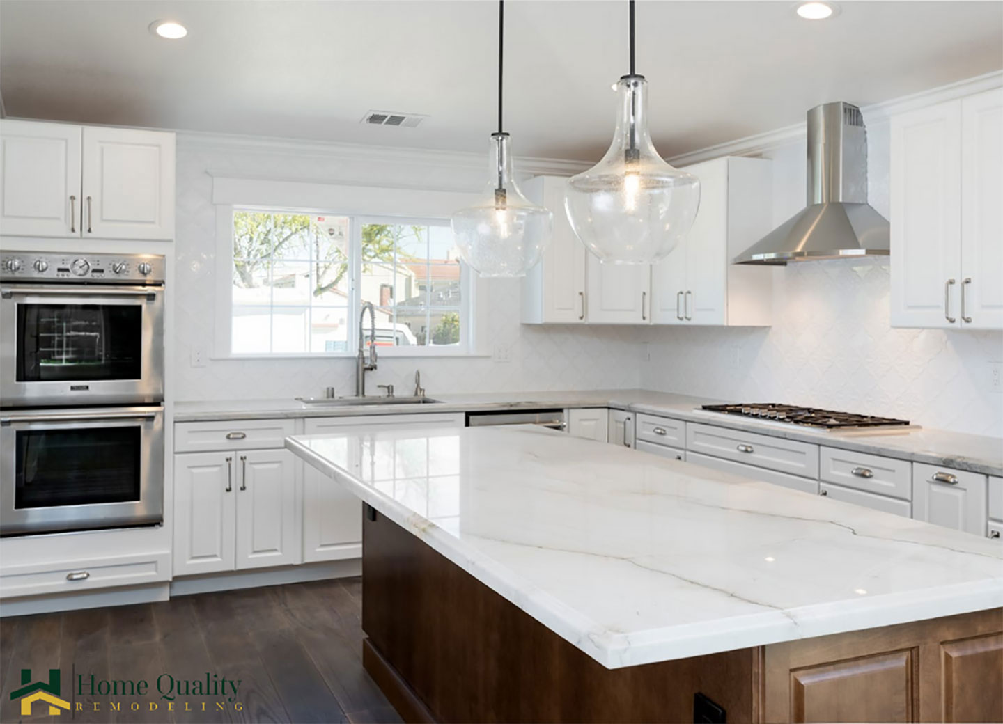 The kitchen has modern appliances, including an oven and sink, and features marble countertops and white cabinets.