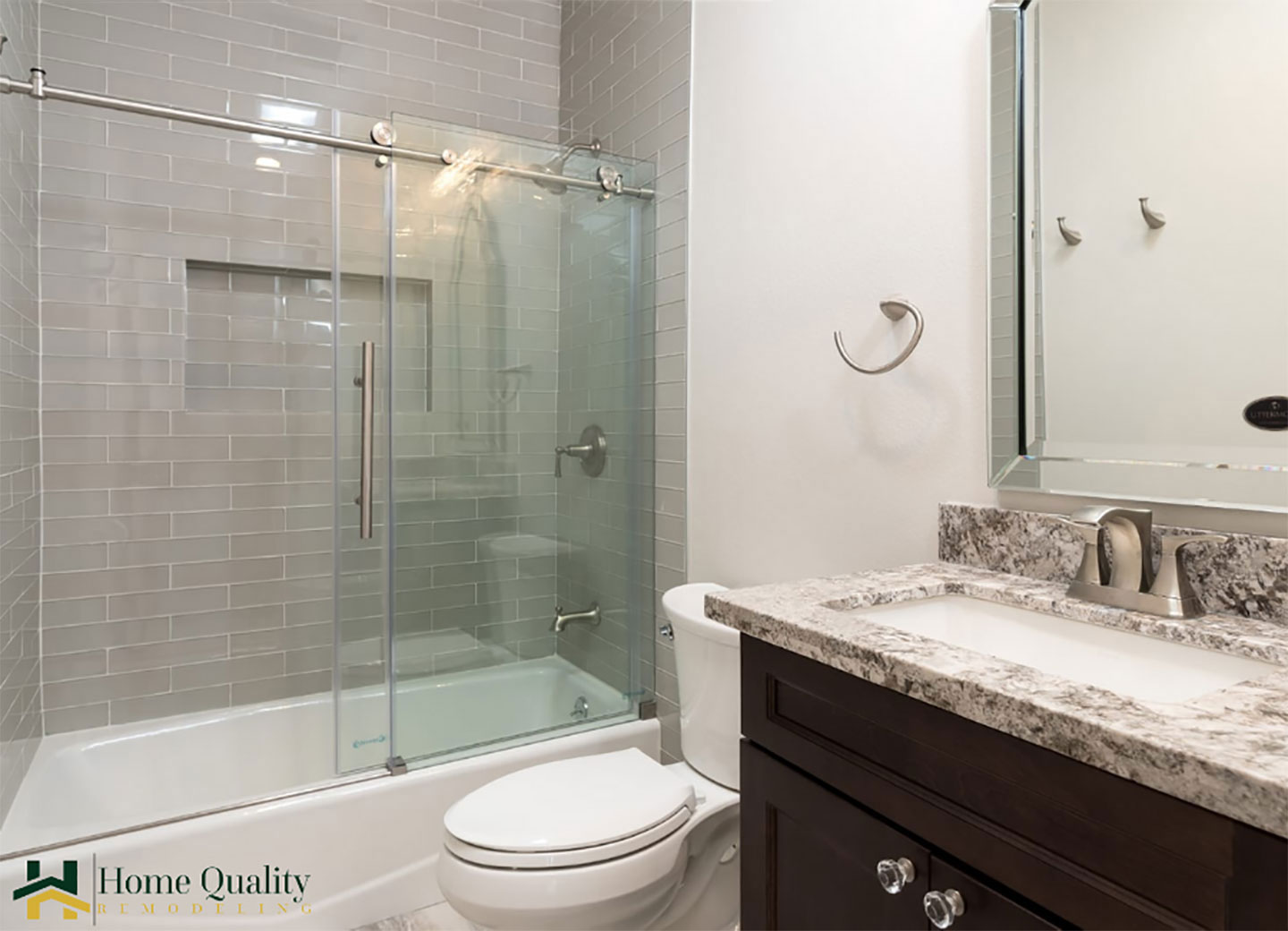 A modern bathroom with a walk-in shower, marble countertops, a double sink vanity, and a clean, white aesthetic.