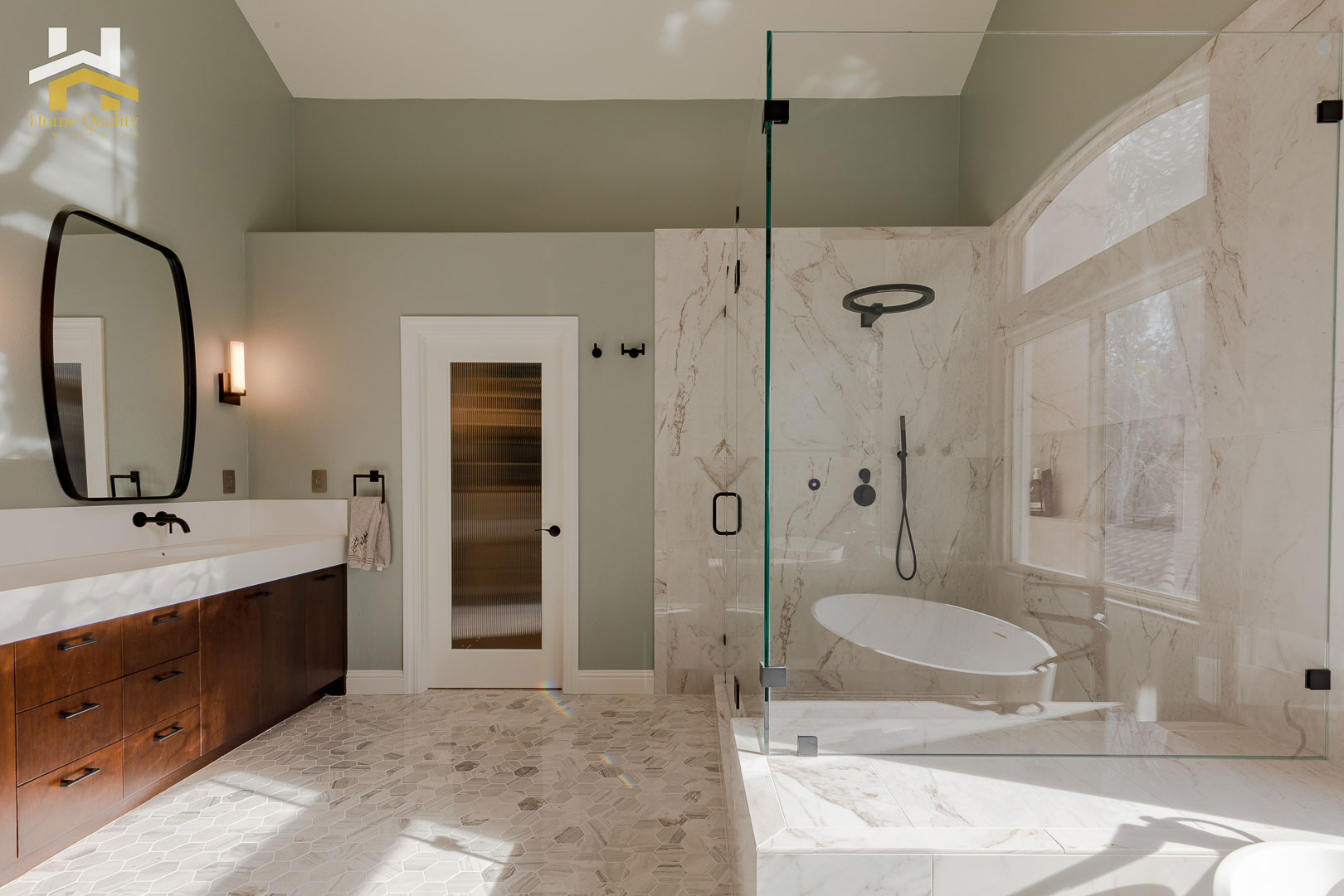 A modern bathroom with a glass shower enclosure, marble flooring, a double vanity sink, and a large mirror above the countertop.