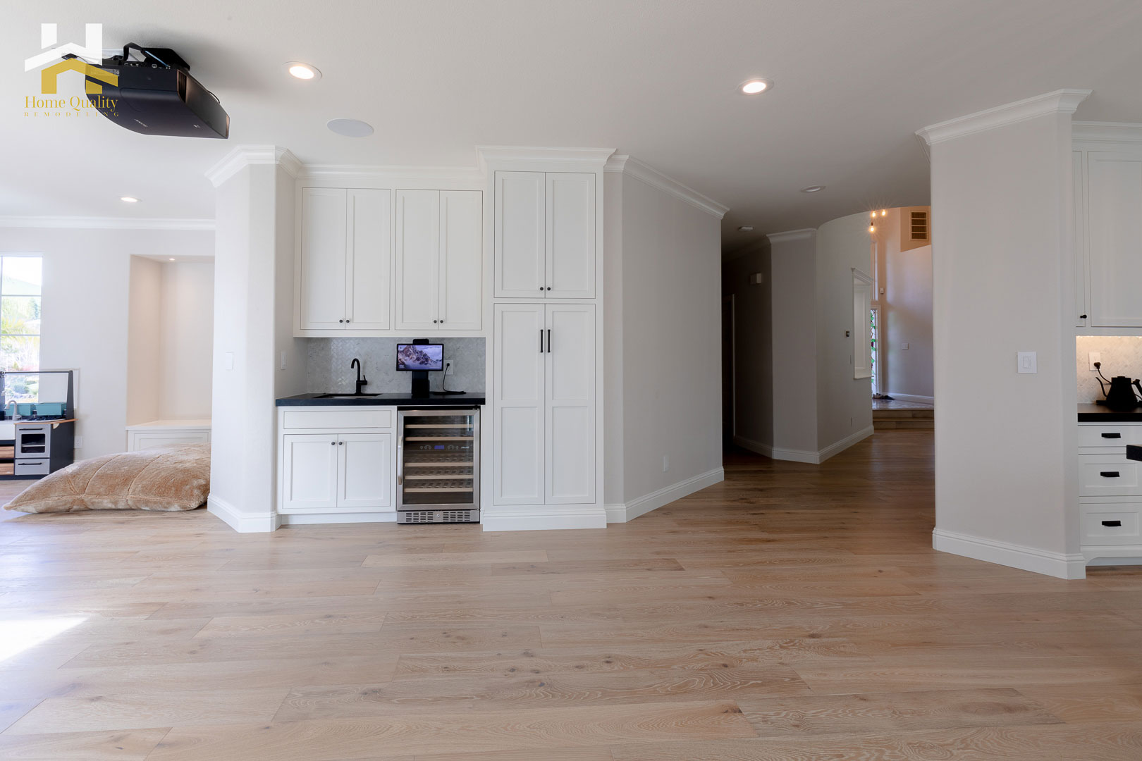 The image depicts a modern kitchen with white cabinets, stainless steel appliances, and a sleek design.