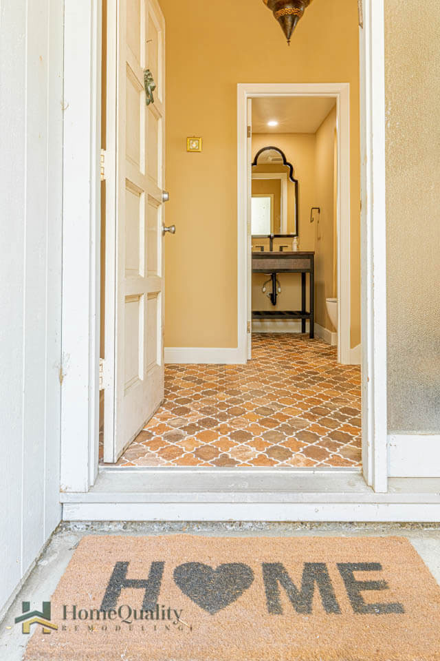 A welcome mat with the words  Home Sweet Home  and a heart shape, placed at an entrance door of a house.