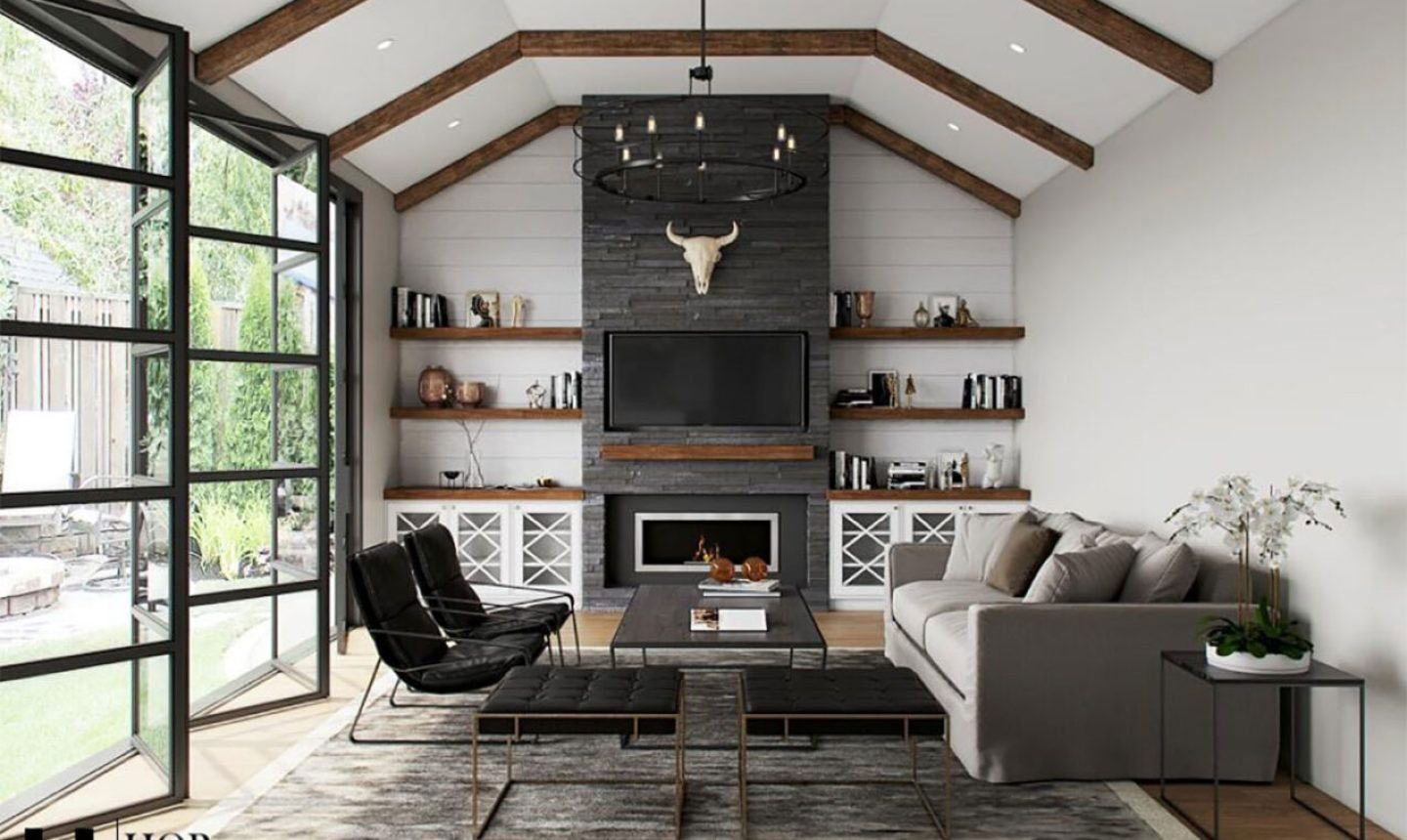 The image shows an interior space designed with a modern aesthetic, featuring a dark wood ceiling, white walls, a large stone fireplace, a sectional sofa, a rugged coffee table, and various decorative items on shelves and in the room.